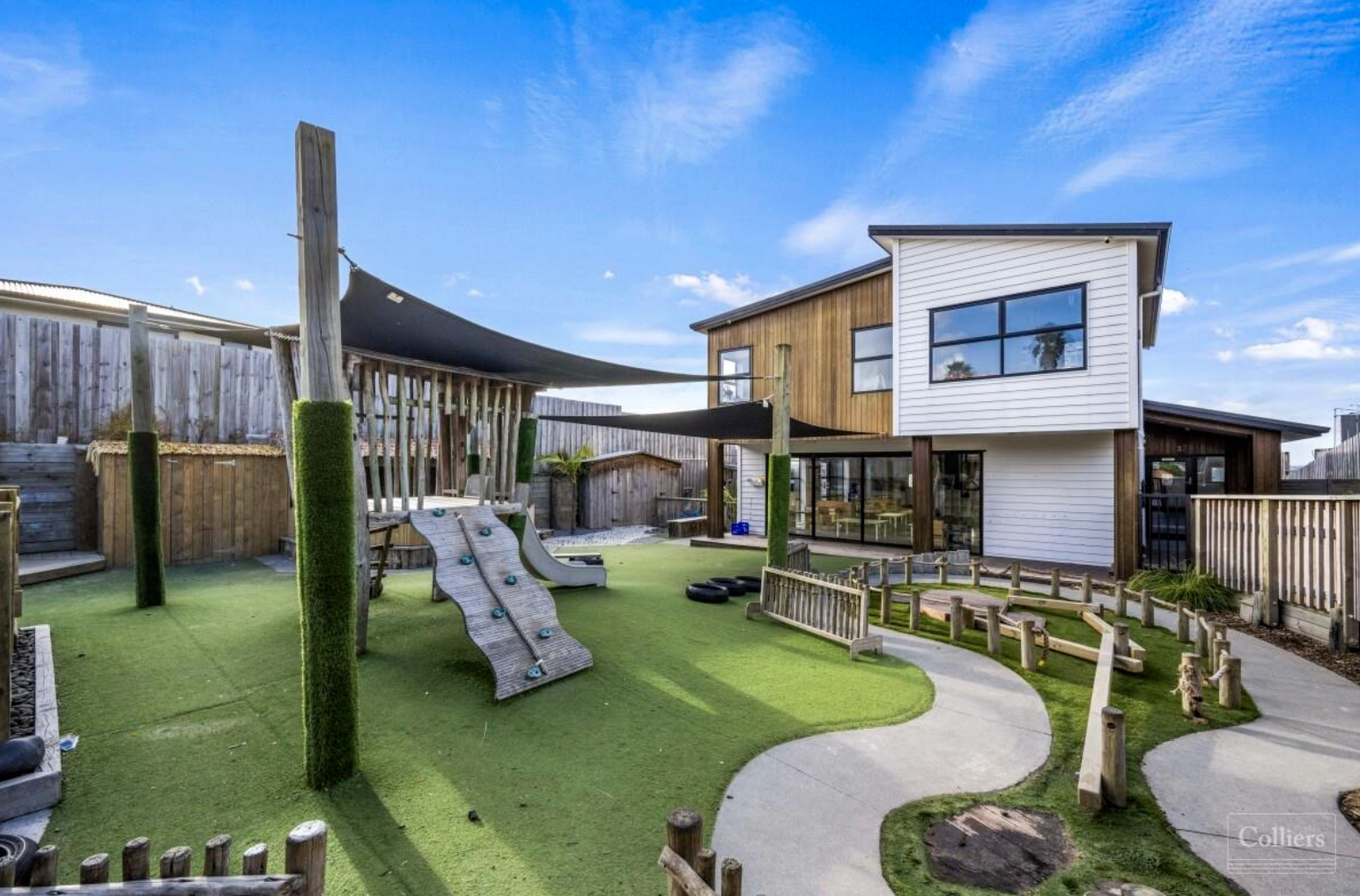 The Village Co outdoor play area with climbing structure and shade sail