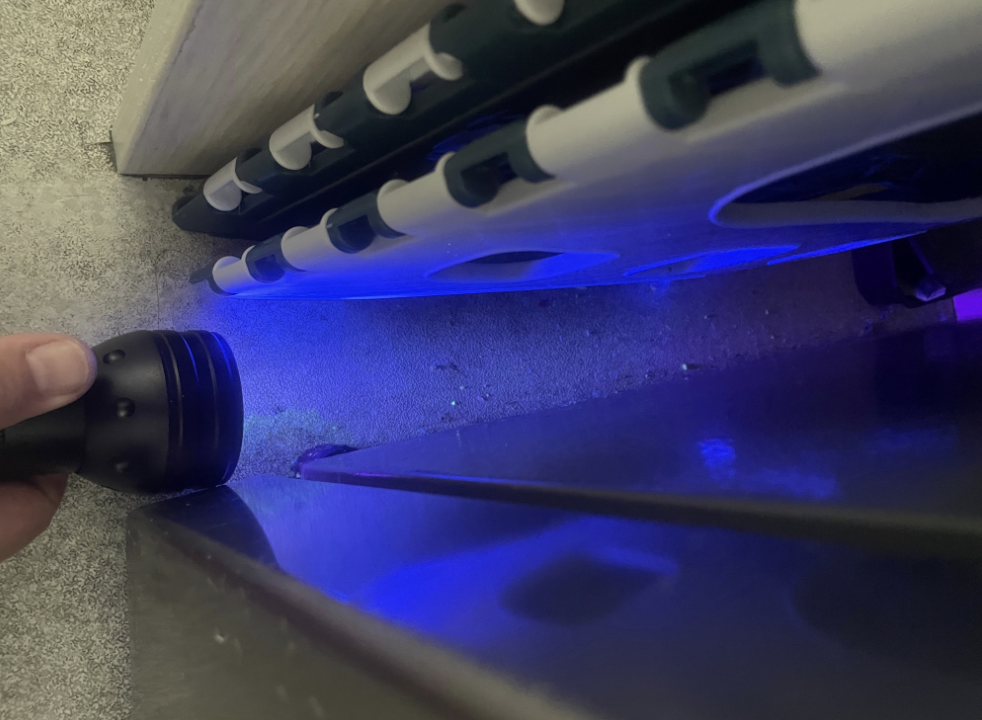 UV torch check along kickboards and edges in a food-prep area