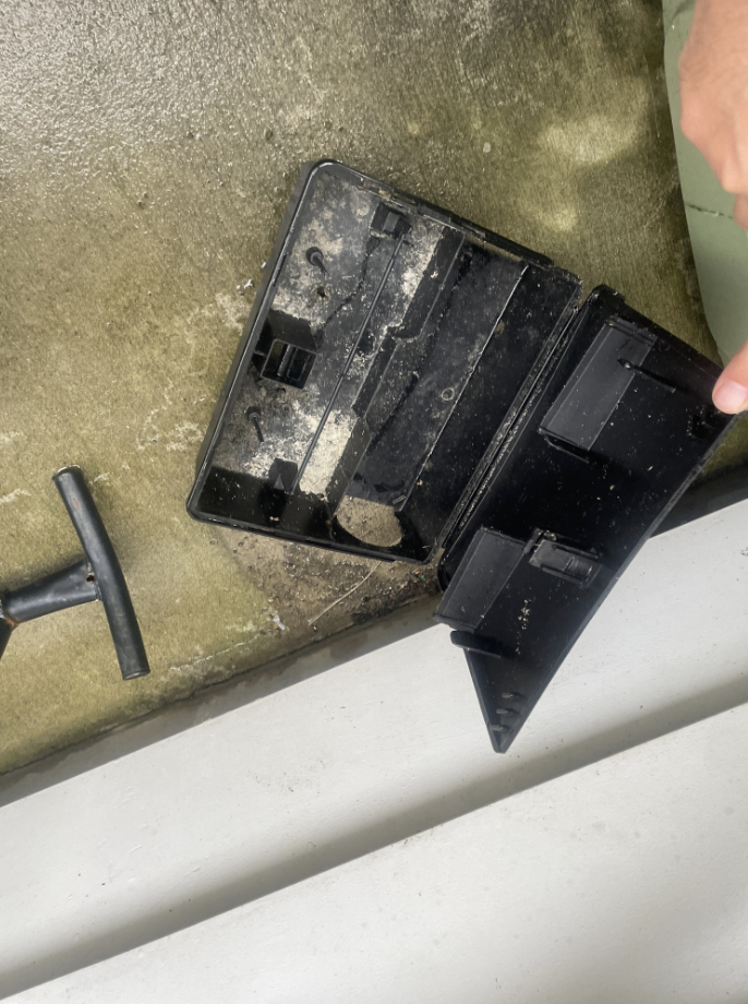 An opened external bait station showing no bait remaining